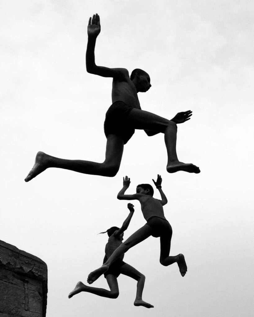 Children jumping a rock