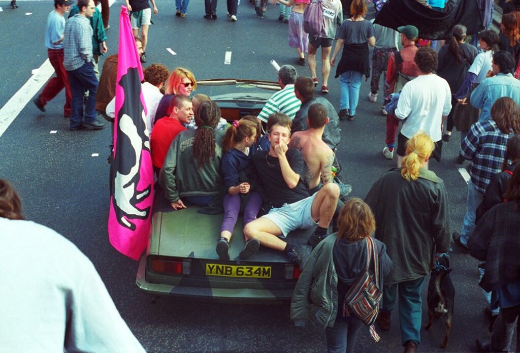 From the move Exist to Resist, a picture showing young people from techno subculture in a car during a public protest