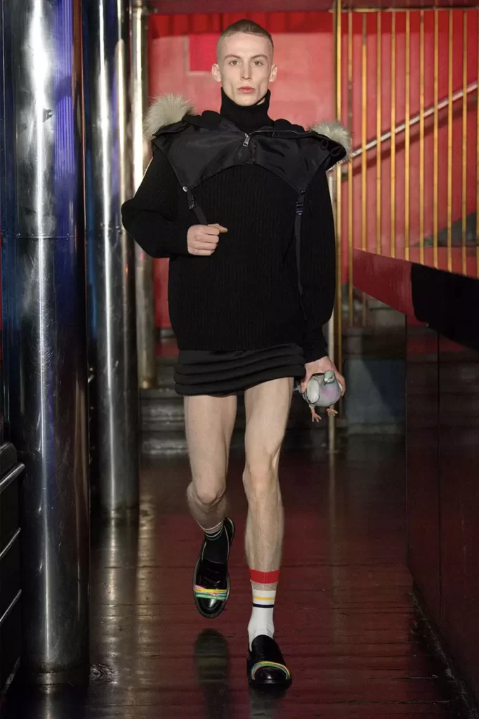 JW Anderson Model on the catwalk, handing the pigeon clutch bag